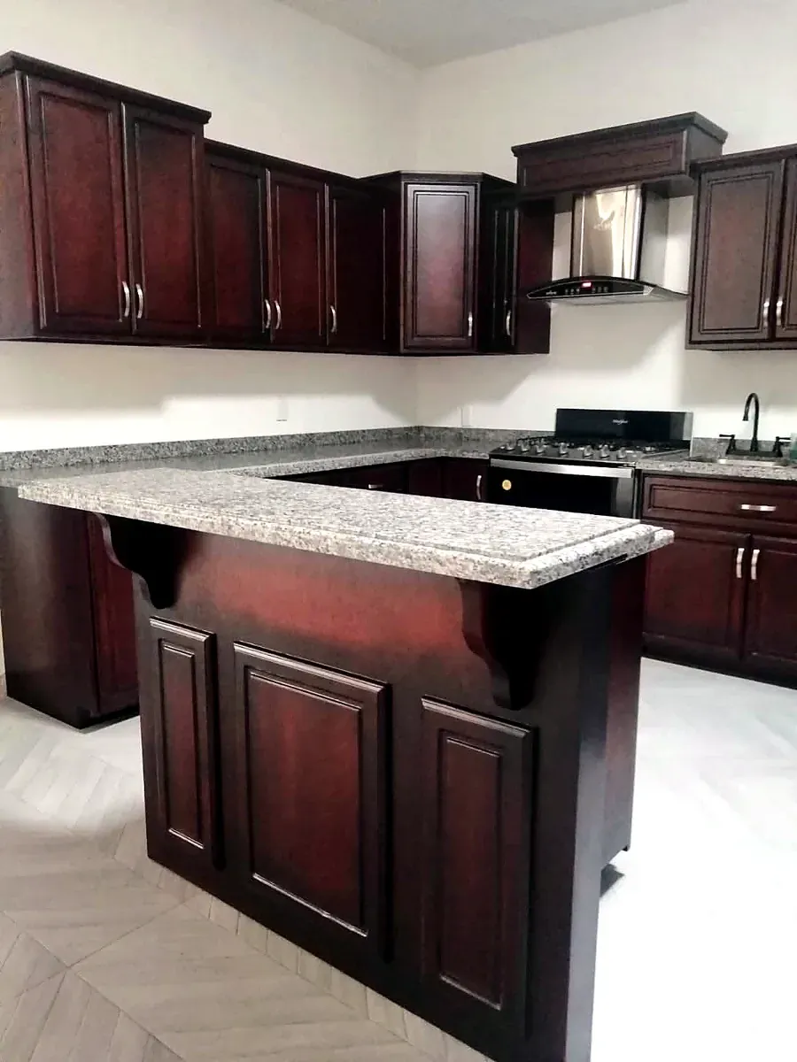 Kitchen with cherry stained cabinetry and a granite topped peninsula